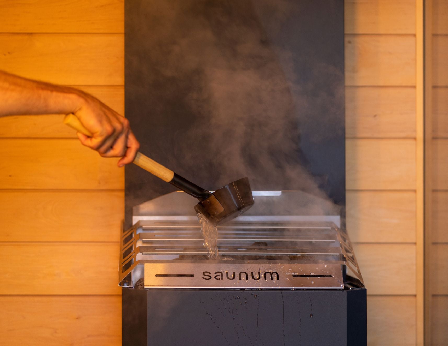 Pouring water on a Saunum Air heater stone pile